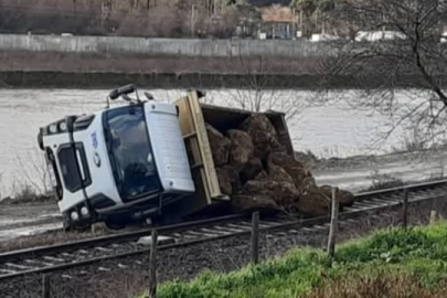 Taş yüklü kamyon raylara devrildi!